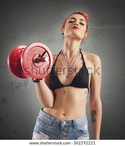 Pin-up girl with tattoo lifting a weight