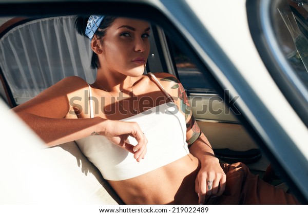 pin-up lady with tattoos\
in retro car