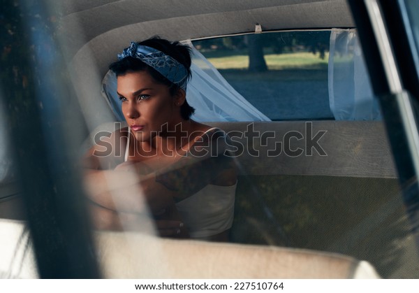 pin-up lady with tattoos\
in retro car