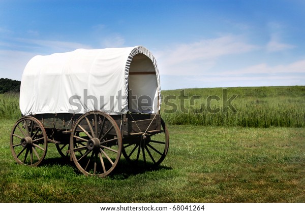A pioneer covered\
wagon on the Prairie.