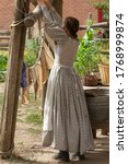 Pioneer woman hanging clothes outside