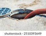 Pipe in the drainage pit. Pumping out sewage from a septic tank. Sewer cleaning service.