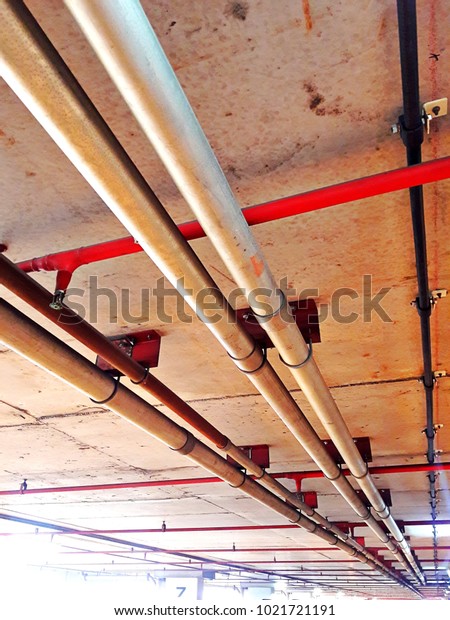 Pipe are\
installed in the ceiling of the floor in the building in car park\
zone as naked that have no anything\
cover
