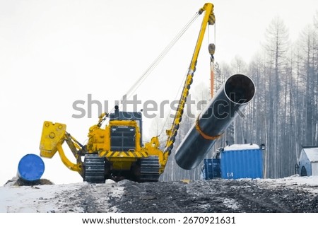 Pipe layer holds a section of pipe on a crane for gas pipeline installation