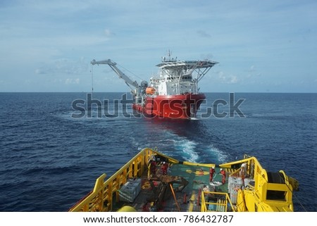 Pipe lifting by dynamic positioning vessel crane at South China Sea, Malaysia. Riggers team get prepared for pipe lifting on anchor handling tug boat deck.