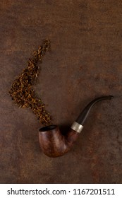 Pipe and tobacco on brown rustic background, top view. - Shutterstock ID 1167201511