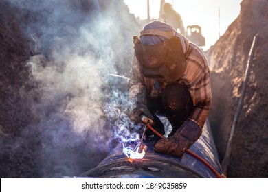 Pipe welding, Worker welding large water pipes in the road construction site