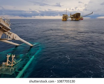 Pipelaying vessel with a pipeline stinger in the water during subsea pipeline construction/installation with an oil and gas platform in the vicinity - South China Sea, Malaysia