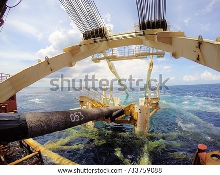 Pipeline exiting pipe tunnel over stinger of pipelay barge into the sea