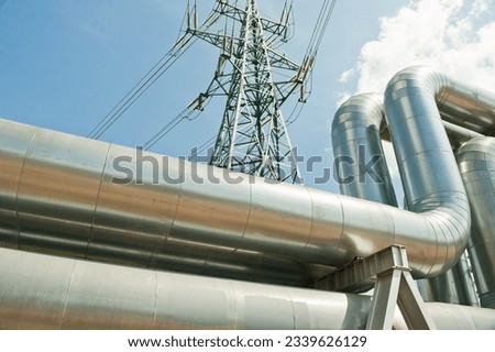 pipeline and power lines against the background of blue sky and clouds.