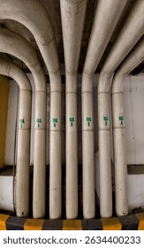 A pipes arranged parallel formation create structured industrial aesthetic, showcasing their smooth surfaces and green markings