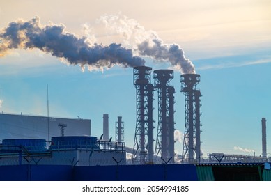 The Pipes Of The A Chemical Plant, From Which Thick White Smoke Rises Into The Blue Clear Sky. Air Pollution! Exhaust Gases, Ozone Depletion, Greenhouse Effect. Industrial Landscape Of Cherepovets.