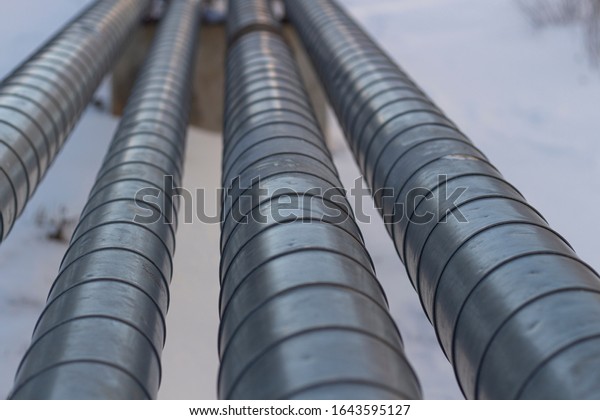 Pipes with\
hot and cold water. City communications. Metal pipes above the\
ground. Element of the water supply\
system.