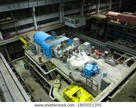 Pipes, steel tubes, steam turbine and equipment at industrial power plant, night scene                       