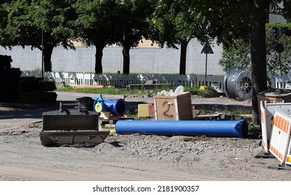 Pipes, Waterline Pieces, Fences And Other Construction Materials On The Ground In A Construction Site In Helsinki, Finland, June 2019. Sunny Summer Day Image. Plumbing And Sewage Repair Materials.