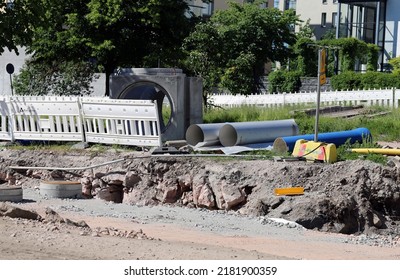 Pipes, Waterline Pieces, Fences And Other Construction Materials On The Ground In A Construction Site In Helsinki, Finland, June 2019. Sunny Summer Day Image. Plumbing And Sewage Repair Materials.