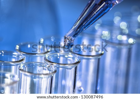 Pipette adding fluid to one of several test tubes