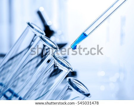Pipette adding fluid to one of several test tubes .medical glassware