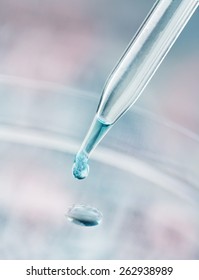 Pipette Dispensing A Fluid Containing A Reflection Of A DNA Sequence Gel