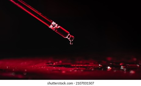 A Pipette And A Drop Of Red Liquid, Water, Poison, Acid, Blood On A Black Background. The Concept Of A Dangerous Product Harmful To Health.