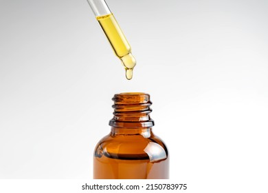 Pipette with falling drop of oil. Dropper with lotion, essence, serum, emulsion. Natural organic cosmetic. Body care concept. - Shutterstock ID 2150783975