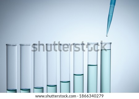 Pipetting. A precision micropipette is used to transfer a small amount of liquid to a test tube. Pipettes are commonly used in chemical and biological laboratory research. 