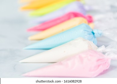 Piping Bags With Pastel Color Royal Icing To Decorate Easter Sugar Cookies.