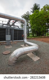 Piping From Below Grade.  Electrical Conduits And Mechanical System Piping In A Cooling Tower Yard.