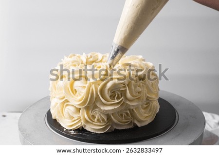 Piping rosettes on a cake using buttercream, Cake being covered in buttercream rosettes, cake being covered in american buttercream, process of decorating a cake