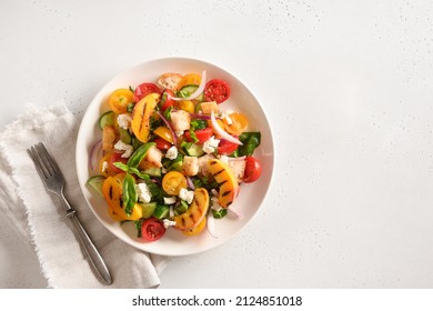 Piquant Panzanella with tomatoes, bread, cheese and grilled peach in plate on white background. Top view. Italian cuisine. Vegetarian panzanella salad. Mediterranean healthy food. Copy space. - Shutterstock ID 2124851018