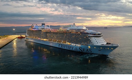 Piraeus Port, Attica - Greece - September 27 2022: Aerial Drone Night Shot Of Huge Brand New Illuminated Cruise Liner Odyssey Of The Seas Departing From Port Of Piraeus To Aegean Island Destinations