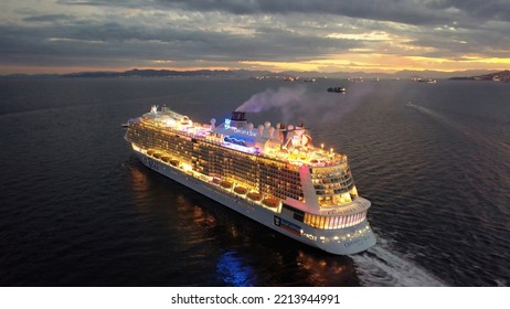 Piraeus Port, Attica - Greece - September 27 2022: Aerial Drone Night Shot Of Huge Brand New Illuminated Cruise Liner Odyssey Of The Seas Departing From Port Of Piraeus To Aegean Island Destinations