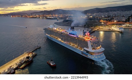 Piraeus Port, Attica - Greece - September 27 2022: Aerial Drone Night Shot Of Huge Brand New Illuminated Cruise Liner Odyssey Of The Seas Departing From Port Of Piraeus To Aegean Island Destinations