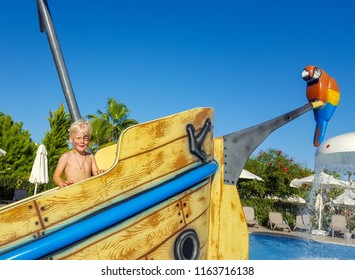  Pirate Day. A little boy looking like a pirate with a parrot is standing on a sinking ship in the pool. It is the view for celebration "International Talk Like a Pirate Day" in september 19. - Powered by Shutterstock