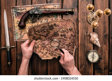 Pirate is exploring a treasure map in his hands top view.