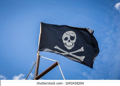 Pirate flag with blue sky skull and crossbones - Shutterstock ID 1692418204