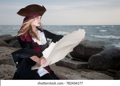 A Pirate Holds Up A Map On The Beach