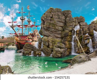 Pirate ship in the backwater of tropical pirate island, with big rock in form of skull near it