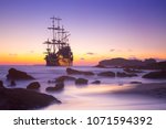 Pirate ship at the open sea at the sunset