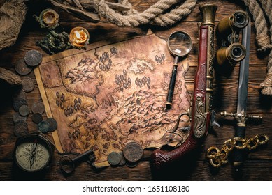 Pirate treasure map and human skull on brown wooden table closeup background.