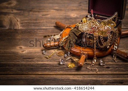 Pirates chest with golden jewelry on wooden background