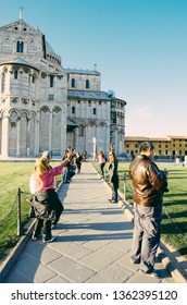 Pisa, Italy - 14 APRIL 2013: Tourist Try With Hands Out As If Hold Up And Brace The Leaning Tower Of Pisa On A Forced Perspective Shot On A Summer Day