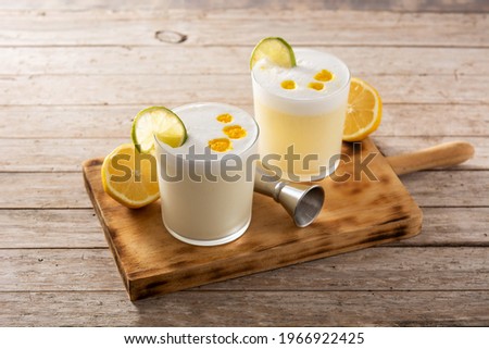 Pisco sour cocktail on wooden table. Traditional peruvian cocktail