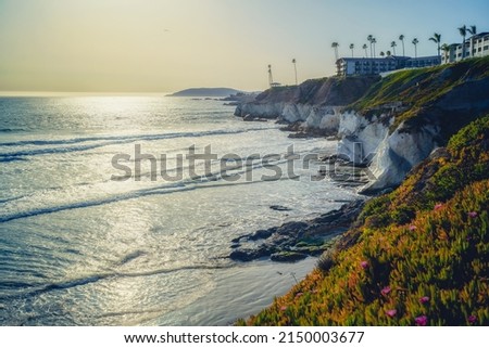 Pismo Beach cliffs at sunset and silhouette of hotels overlooking the water's edge, California Central Coast.