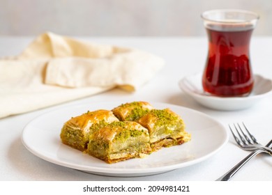 Pistachio baklava dessert on a white background. Turkish sweet dessert concept. plate of pistachio baklava. sherbet sweet Mediterranean bakery. close up. Horizontal view. Local name fistikli baklava - Shutterstock ID 2094981421