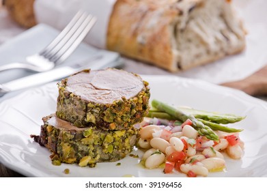 Pistachio Crusted Lamb With Bean Salad Served On A Plate And A Home Baked Style Whole Meal Bread On The Side