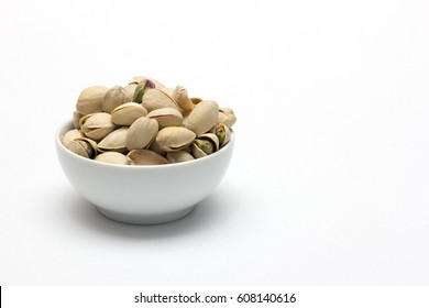 Pistachios in ceramic bowl on white background. - Shutterstock ID 608140616