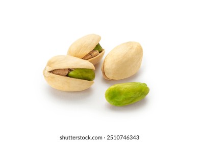 The pistachios are lying on a white surface. Peeled kernels of nuts. Unpeeled kernels of nuts. Pistachios isolated on white background.