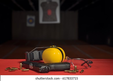 Pistol, Bullets, Ear Protection, Eyeglasses At Shooting Range