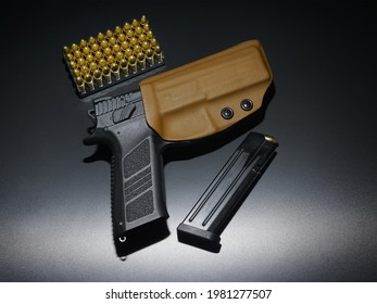 Pistol in a kydex holster. Pack of fifty 9mm cartridges and loaded magazine.